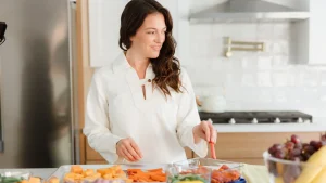 woman in the kitchen eating carrots during intermittent fasting window.