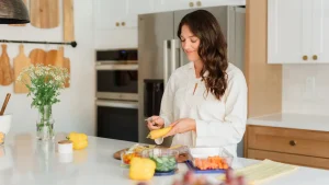 Woman in kitchen preparing meal using high protein breakfast ideas.