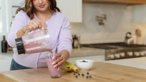 woman pouring fruit smoothie into glass example of foods for brain fog.