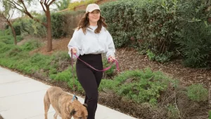 woman walking her dog, one way to support mitochondrial health.