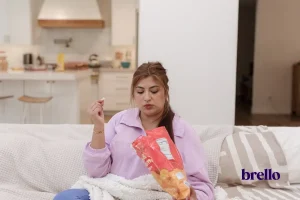 woman in living room eating back of chips - how to stop emotional eating article.