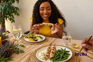 woman eating shish kabob, example of high protein dinners on a GLP-1.