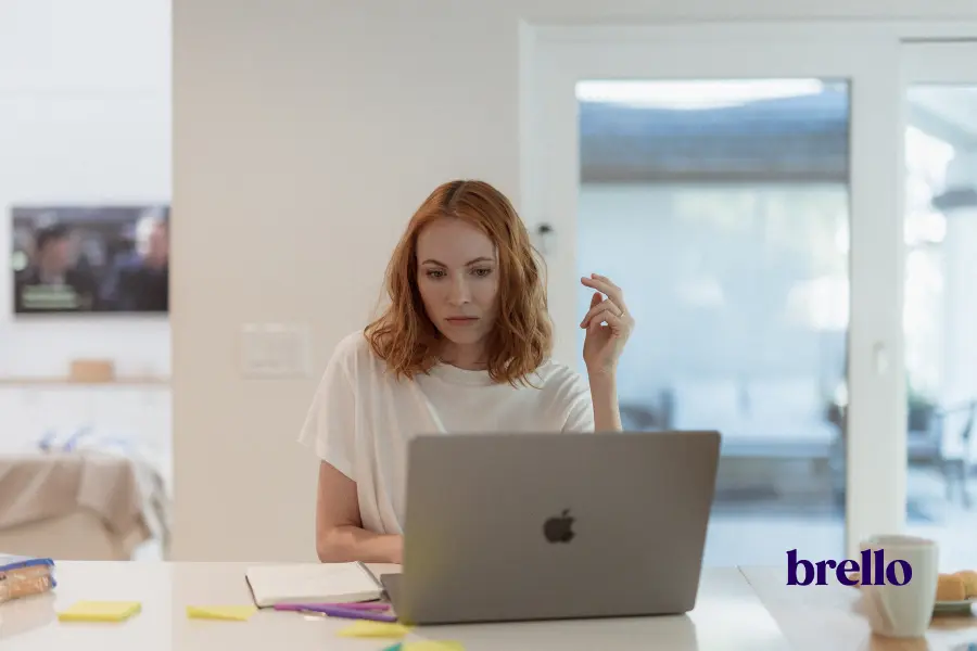 Woman distracted at her laptop, thinking through her mental load