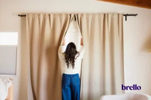 Woman opening curtains representing nervous system regulation.
