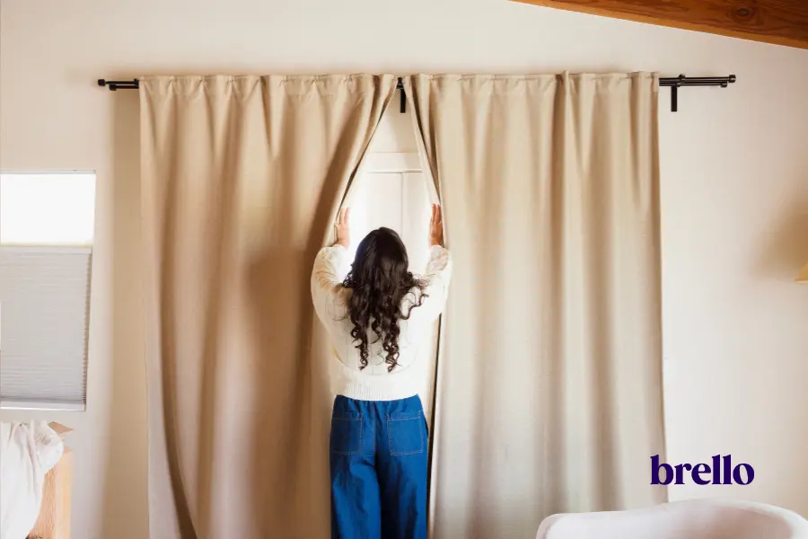 Woman opening curtains representing nervous system regulation.
