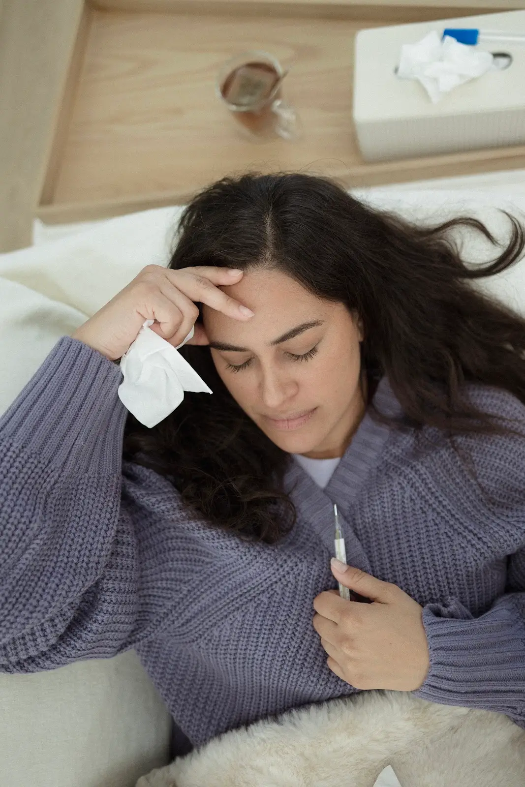 Woman resting and recovering with the best electrolytes for hydration during illness