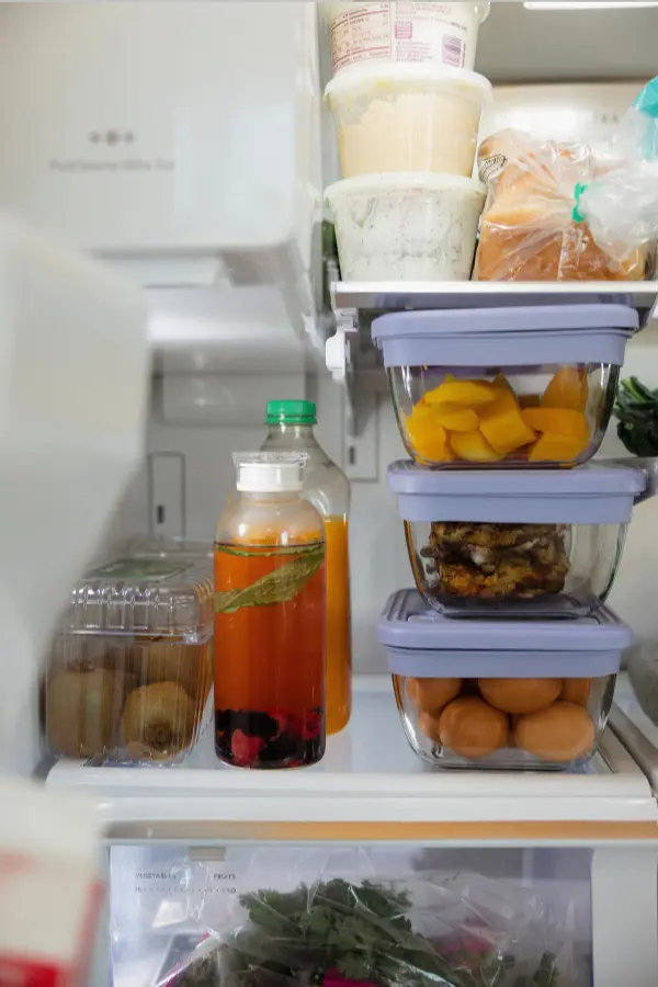 Stacked glass meal containers on a refrigerator shelf
